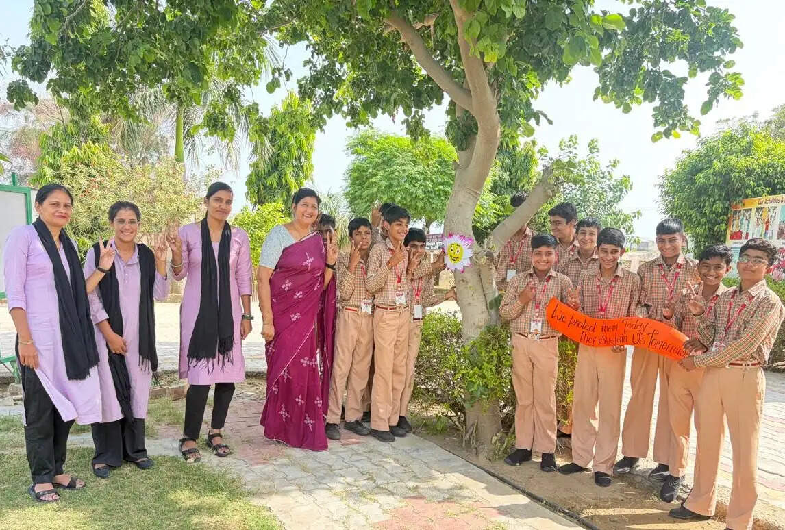संत कबीर इंटरनेशनल स्कूल में पेड़ पर राखी बांधते विद्यार्थी