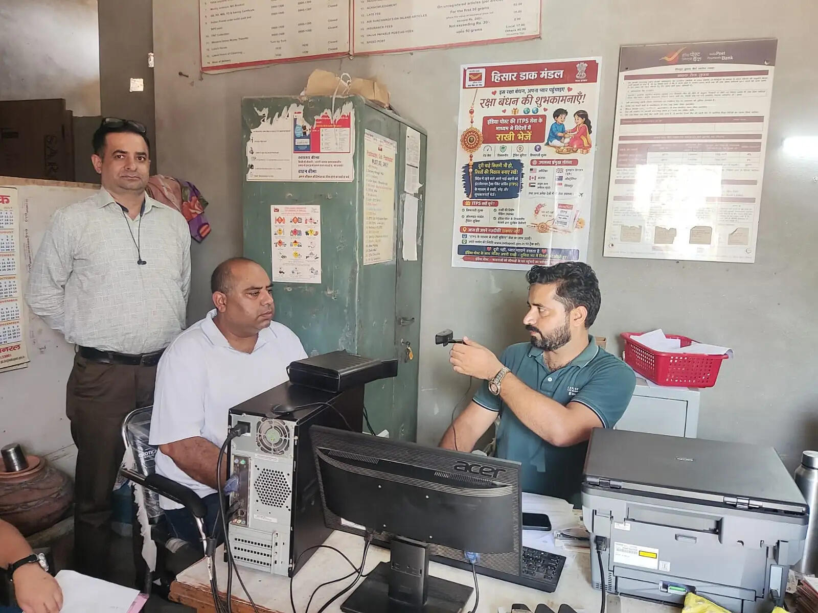 सिरसा के भावदीन गांव में डाक विभाग के आधार अपडेट कैंप में ग्रामीणों के Aadhaar का काम करते कर्मचारी