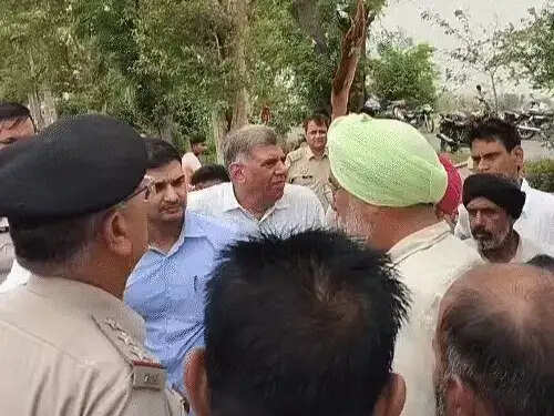 फतेहाबाद के टोहाना में खेत में पलटी हुई प्राइवेट बस और सड़क पर जाम लगाकर प्रदर्शन करते हुए ग्रामीण